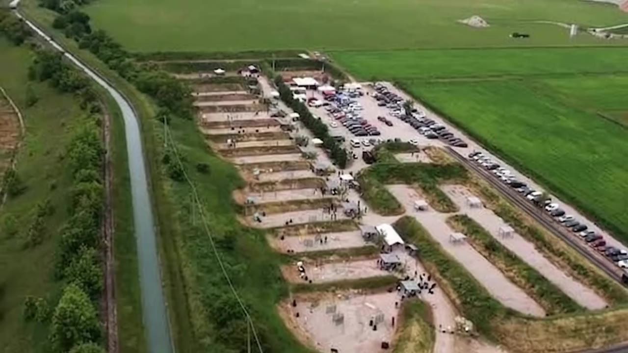 Vista aerea del poligono: campi di tiro dinamico lungo il canale, parcheggio e linee di tiro
