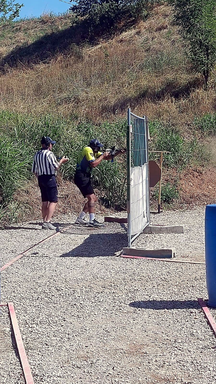 Stage di tiro dinamico tra i terrapieni, con tiratore e range officer